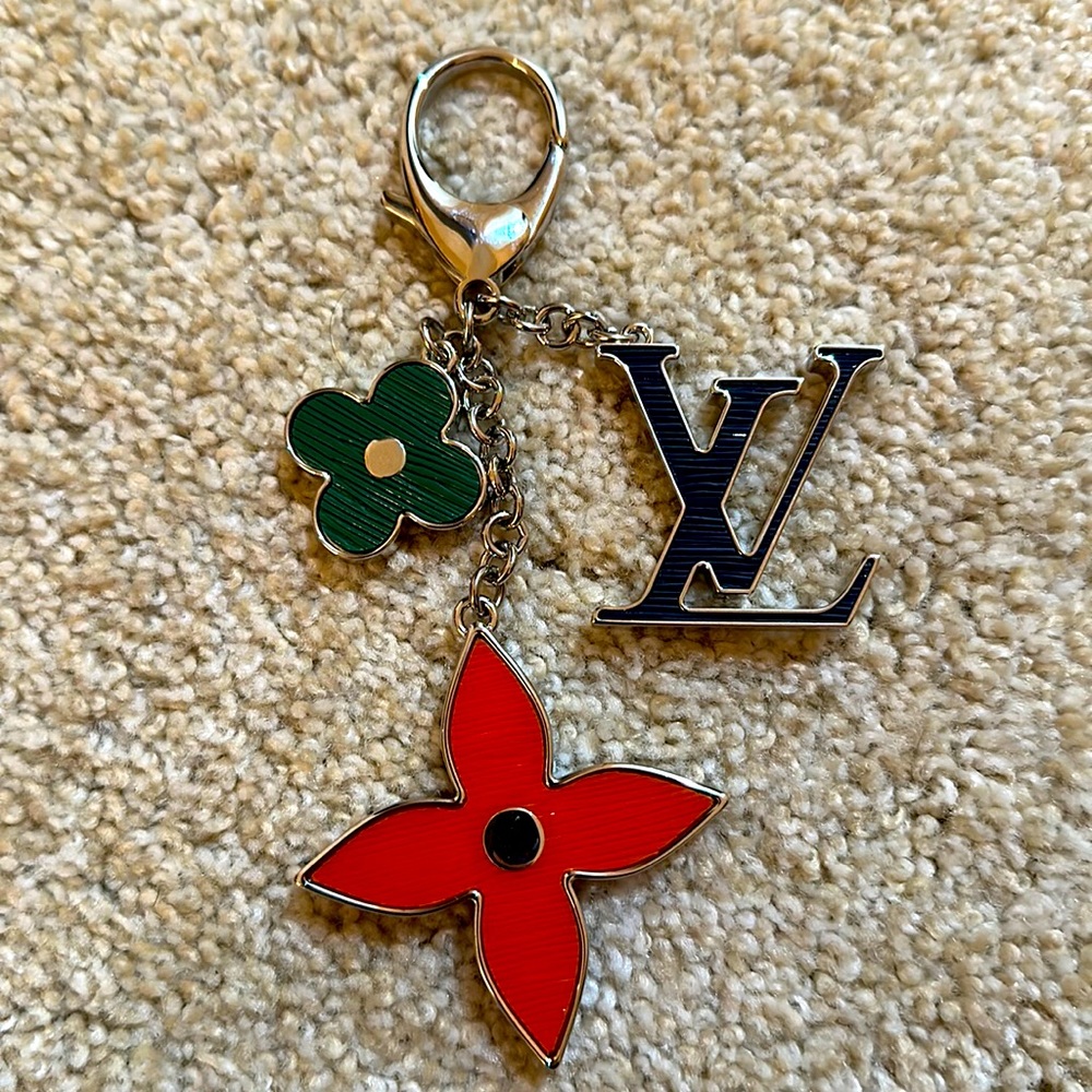 Louis Vuitton fleur bag charm in black, green and orange.